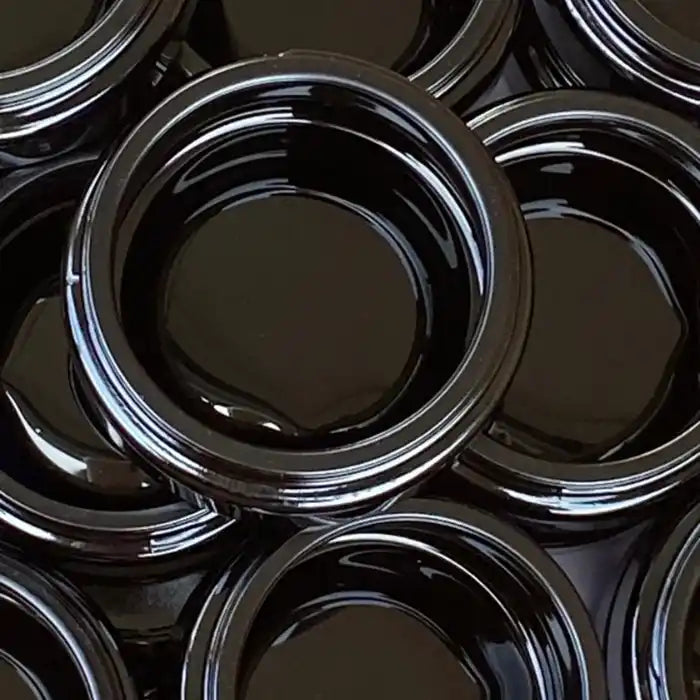 Black plastic lids arranged in a circular pattern.