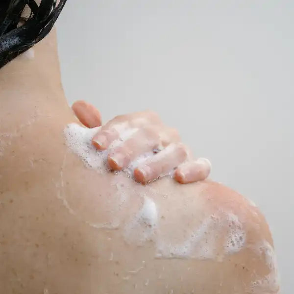 Soapy hand washing skin with white lather and bubbles.