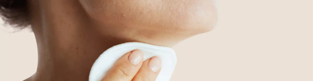 White cotton pad or facial tissue being held against skin.