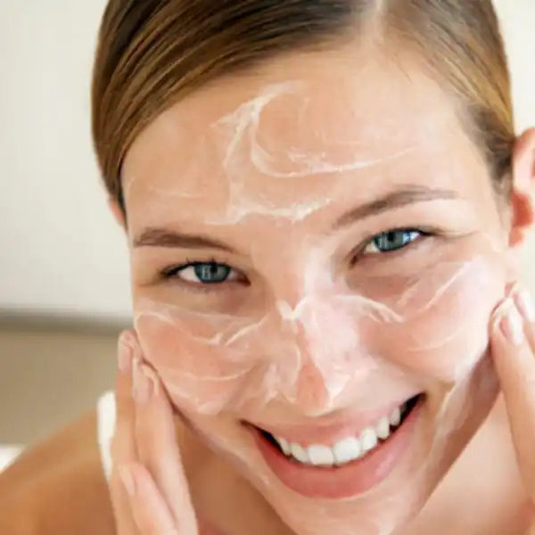 White facial moisturizer or cream being applied to glowing skin.